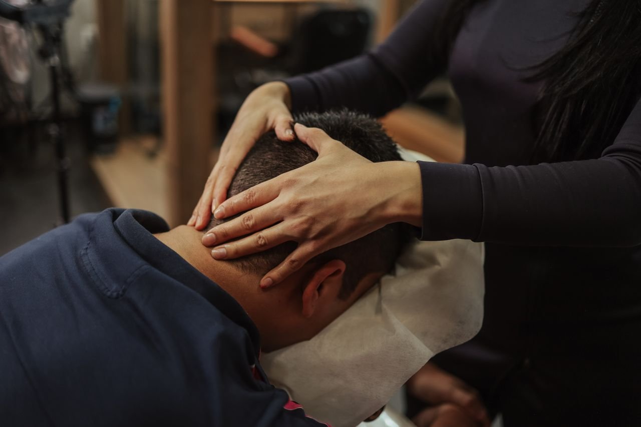 Services A person receiving a soothing head massage at a salon, creating a calming experience.